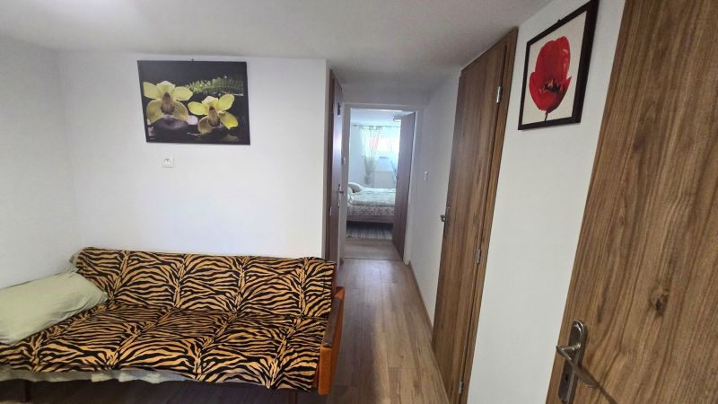 A hallway in a family house with a zebra-patterned sofa and paintings on the walls.