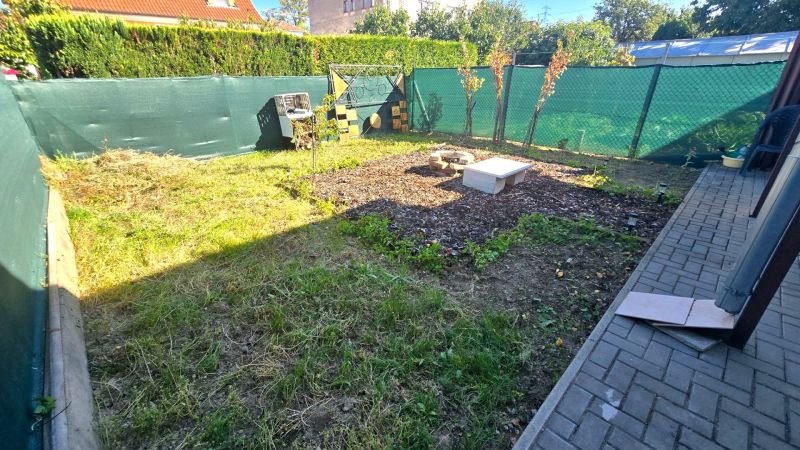 The garden of a family house on Kupeckého Street in Piešťany with a lawn and a flower bed.