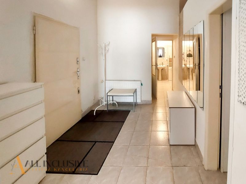 Entrance hallway in a 2-room apartment with tiles and a mirrored wall.