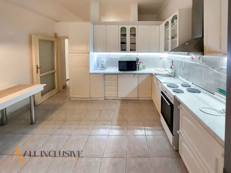 A kitchen with a white cabinet and a dining table in a 2-room apartment.