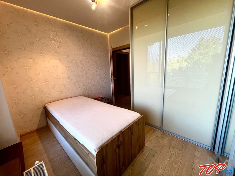 Bedroom in a 3-room apartment with a bed, built-in wardrobe, and decorative wall.