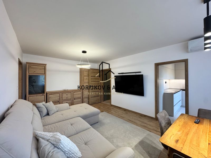 Living room in a 3-room apartment with a wooden decor floor and modern furniture.