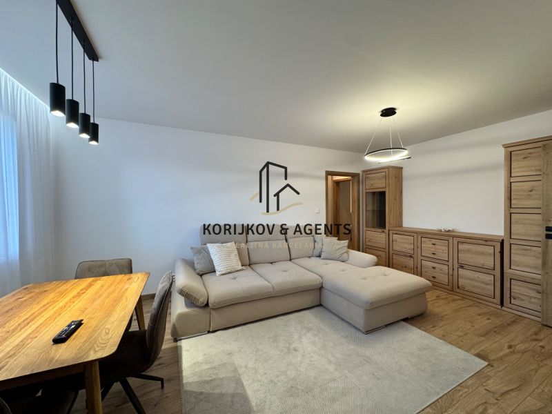 A living room in a 3-room apartment with a wooden decor floor and a comfortable sofa.