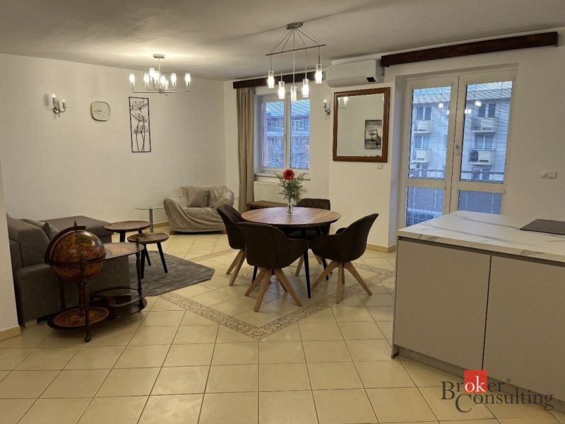 Open living space with a dining table and cream tiles in a 3-room apartment.