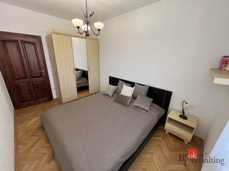 Bedroom in a 3-room apartment with a double bed and a wardrobe, floor with wooden decor.