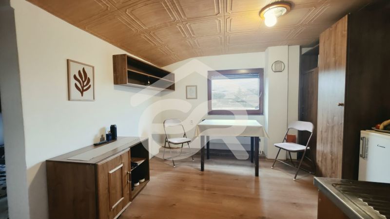 Interior of a holiday apartment with wooden decor furniture and folding chairs.
