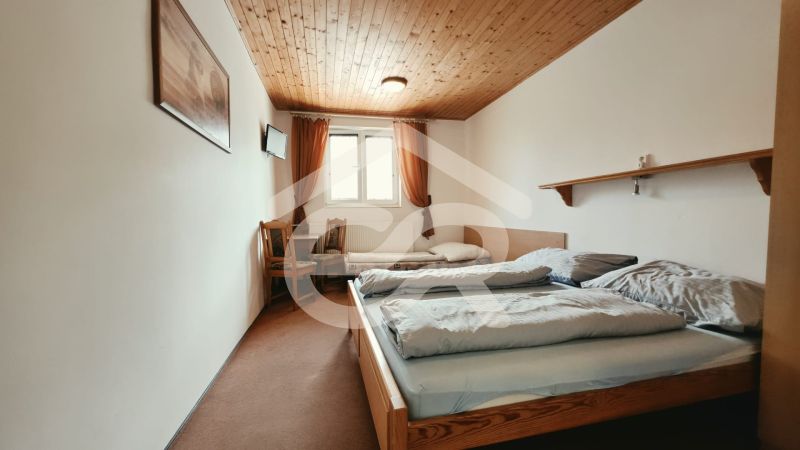 Bedroom in a Holiday Apartment with two beds and a TV, floor with wooden decor.