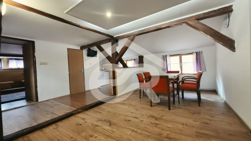 Dining room with wooden beams and a floor with a wooden decor in the Holiday Apartment.