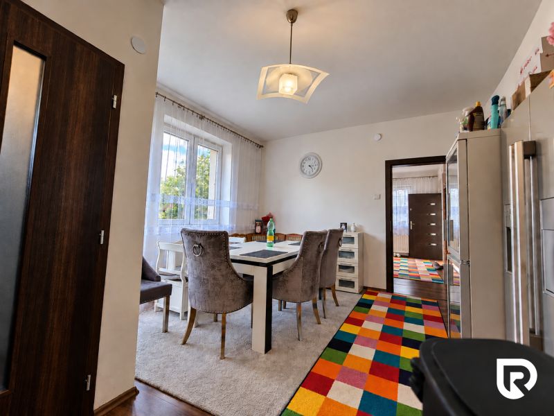A dining room in a family house with a cheerful carpet design and a wooden floor design.