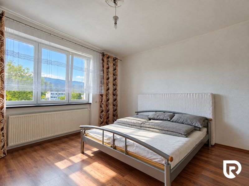 A bedroom in a family house with a bed and a wooden decor floor.