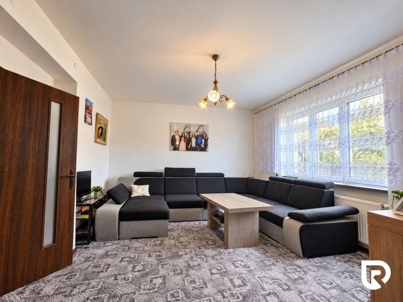 Living room in a family house with a large sofa and a striking carpet.
