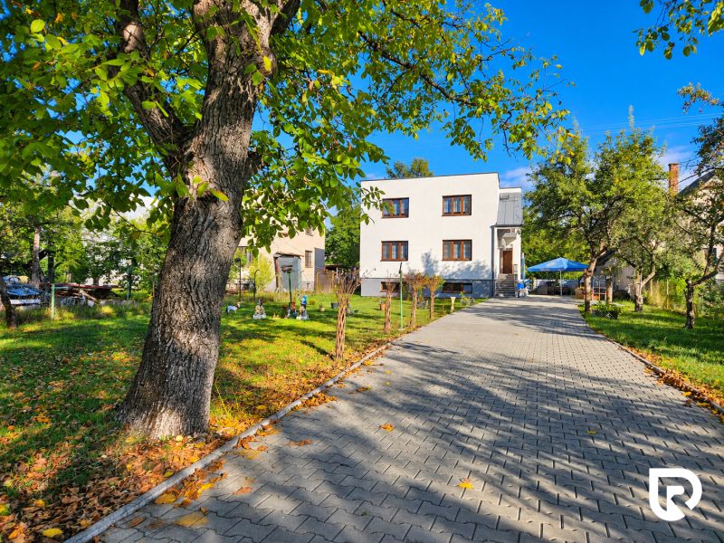 A family house in Martin with a garden, trees, and a paved walkway.