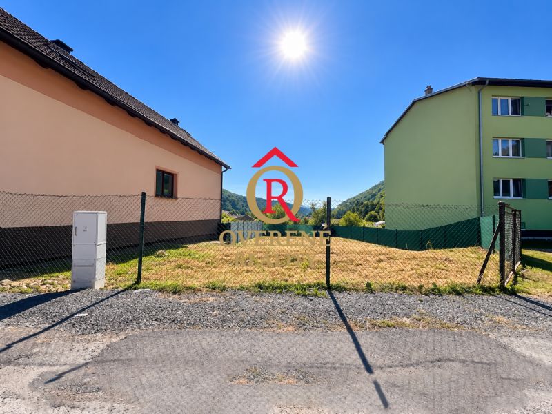 Building plot in Sebedín-Bečov on Sebedín Street, fenced, next to buildings.