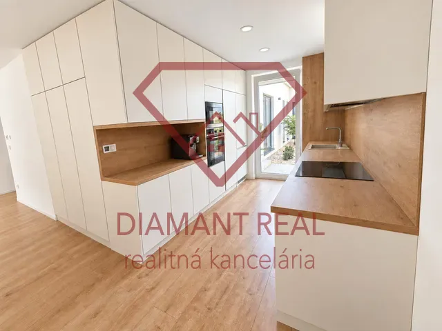 A family house kitchen with a wooden decor floor and white cabinets.