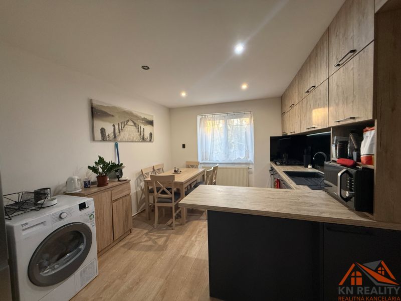 A kitchen in a 2-room apartment with a wooden decor floor and modern equipment.