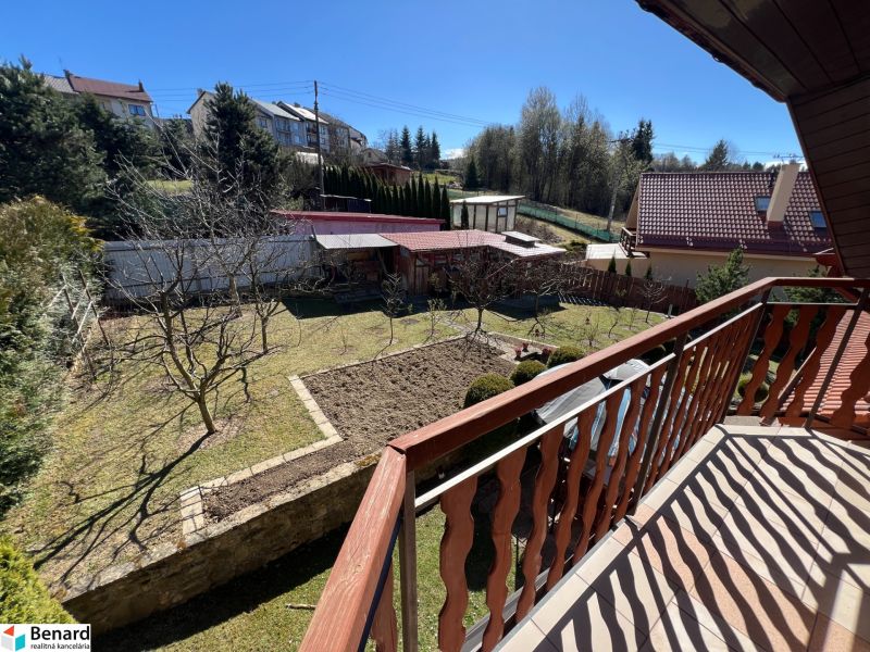 View from the balcony of a family house in Stará Ľubovňa, garden with lawn and trees.
