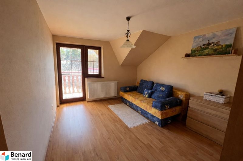 Interior of a room in a family house with a wooden decor floor and a sofa.