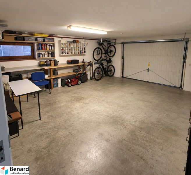A garage in a family house with folding bicycles, a lawnmower, and shelves for tools.