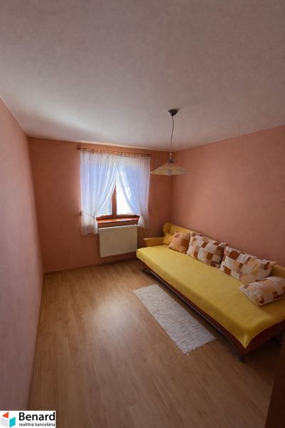 A room with wooden floor decor and a sofa in a family house.