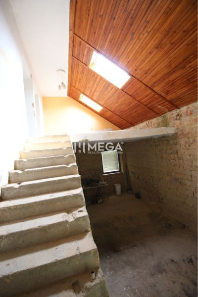 Staircase and attic with wooden ceiling paneling in a family house.