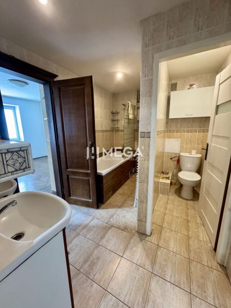 Bathroom in a 3-room apartment with tiles and white sanitary ware.