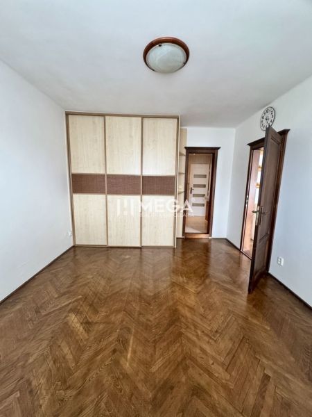 A room in a 3-room apartment with a wood-patterned floor and a built-in wardrobe.