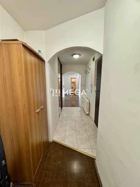 A hallway in a 3-room apartment with tiles and a floor with a wooden decor.