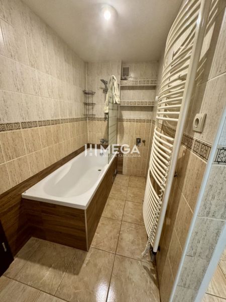 Bathroom with tiles, a bathtub, and a ladder radiator in a 3-room apartment.