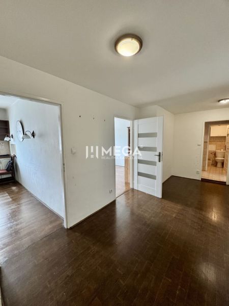 A hallway with a wooden decor floor and doors in a 3-room apartment.