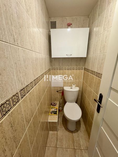 A bathroom with tiles and white furniture in a 3-room apartment.