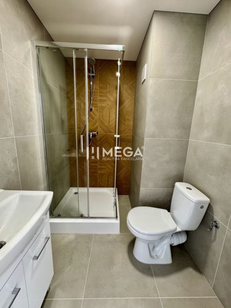 Bathroom in a studio apartment with a shower and ceramic tiles.