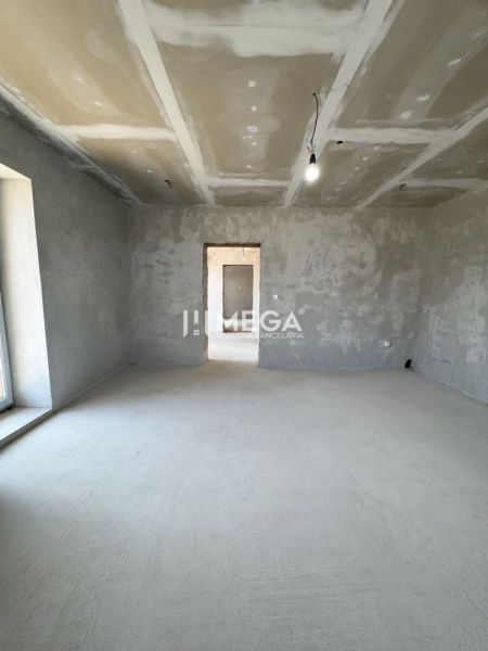 Empty room in a family house with plastered walls and a single light.