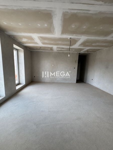 Interior of a family house with a neutral floor and a large window, ready for modifications.