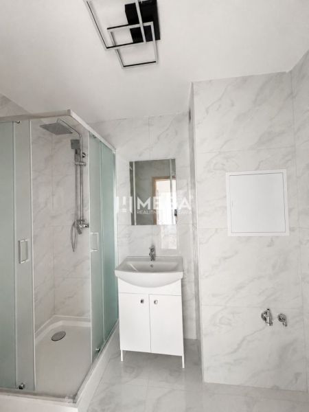 A bathroom in a 3-room apartment with a modern shower and a white sink.