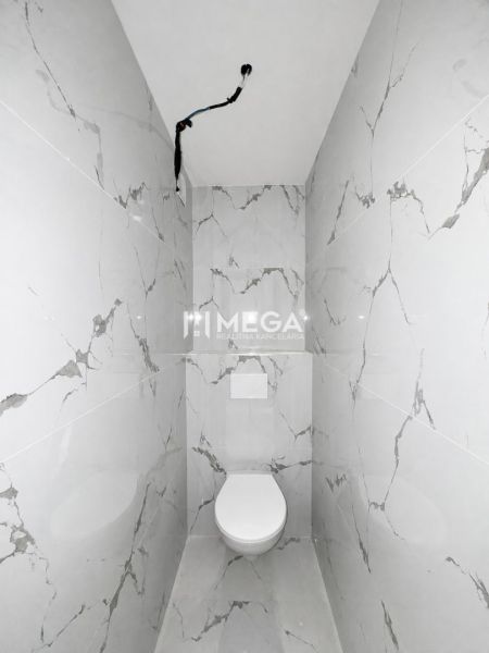 A bathroom in a 2-room apartment with marble tiles.