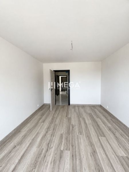 2-bedroom apartment with wood-patterned flooring and open doors.