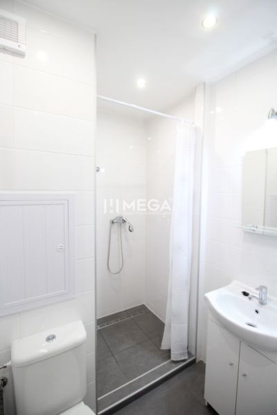 Bathroom in a holiday apartment with a toilet, shower, and sink.