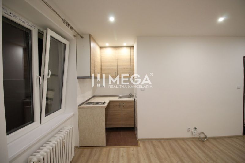 A kitchen in a holiday apartment with a kitchen unit and a wooden decor floor.