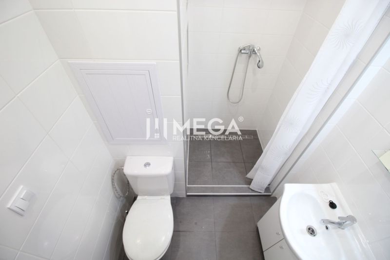 Bathroom in a holiday apartment with a toilet, shower, and sink.
