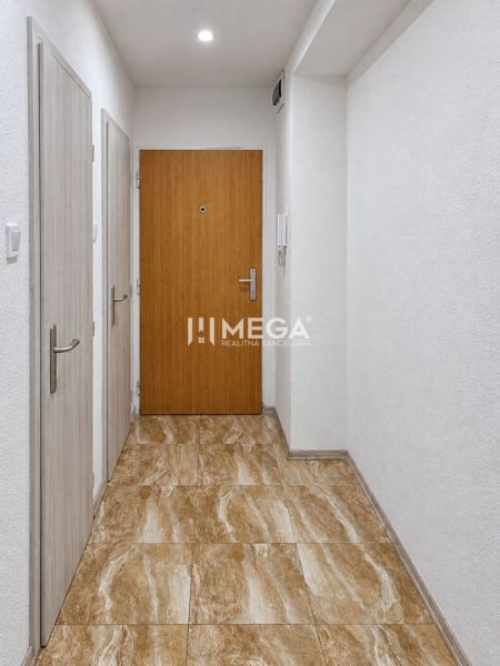 The entrance hall of a 2-room apartment with a marble-patterned floor and white walls.