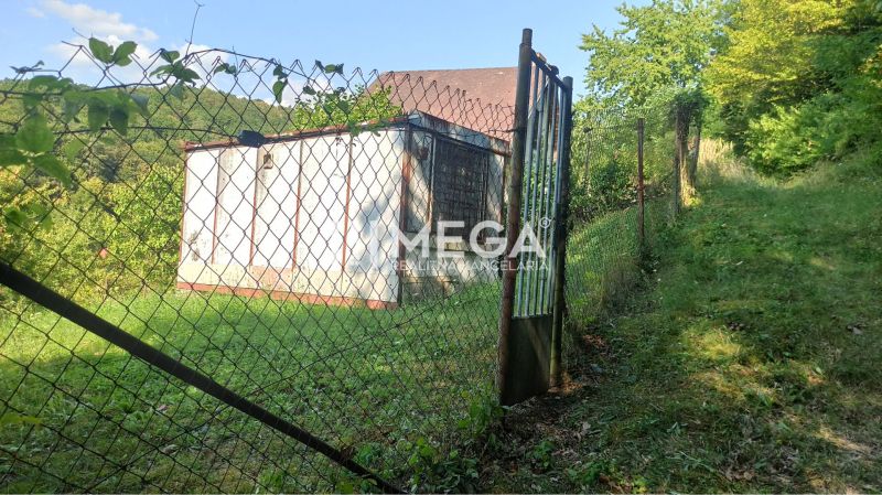A gate plot in the gardens of Humenné, surrounded by lush greenery and hills.