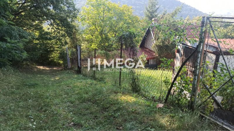 A cottage with a garden surrounded by a fence in the town of Humenné on the edge of nature.