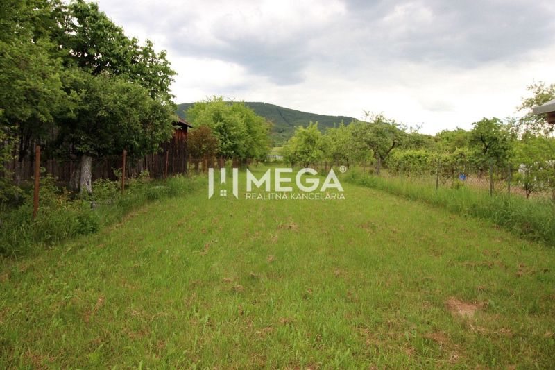 Green residential plots in Ptičie on Ptičie Street, surrounded by trees and mountains.