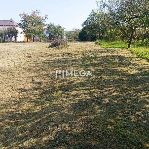 A grassy plot in Humenné for residential purposes, surrounded by greenery and trees.