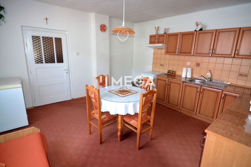 A kitchen in a family house with wooden decor cabinets and a round table.