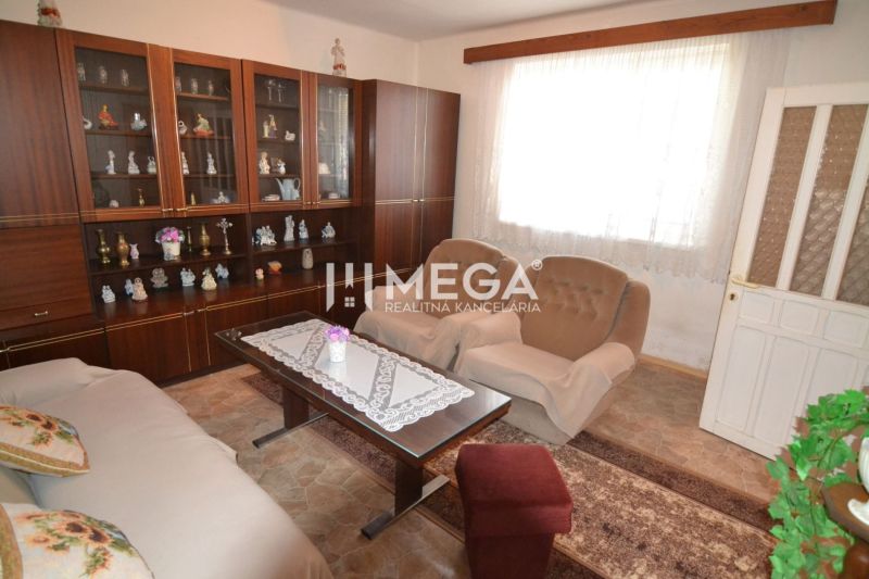 Living room in a family house with a display cabinet, armchairs, and a table with lace.