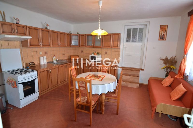 A kitchen in a family house with wooden cabinets and a dining table.