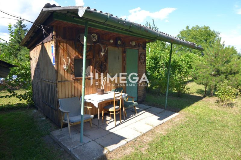 A small wooden garden cottage with a shelter in the garden of a family house in Hažín nad Cirochou.