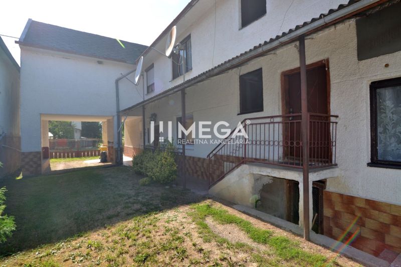 A family house in Hažín nad Cirochou with a green yard and metal stairs.
