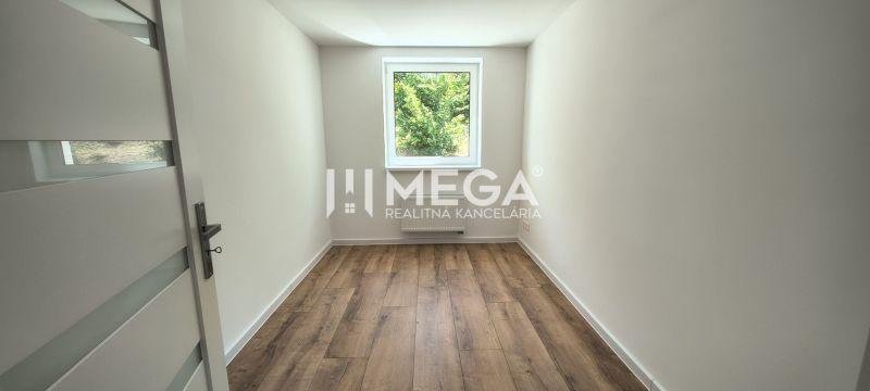 A room in a 4-room apartment with a wooden decor floor and a view from the window.